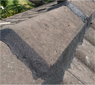 Picture of a stone roof patched and cemented with black cement or material